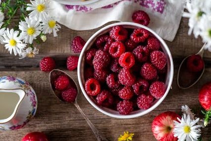Eine Schüssel mit Himbeeren steht auf dem Tisch.