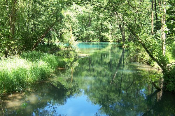 In einem Quell-See spiegelt sich der blaue Himmel.