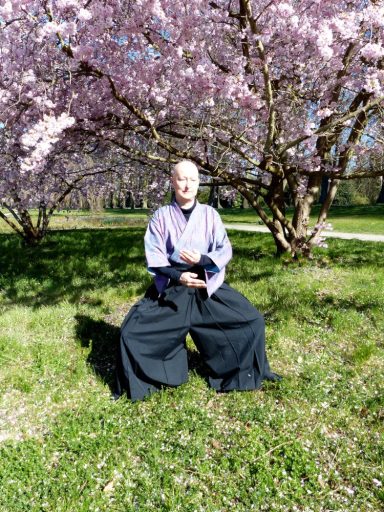 Carla Neß steht in Meditation.